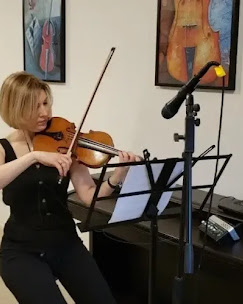 Mira playing violin in her studio